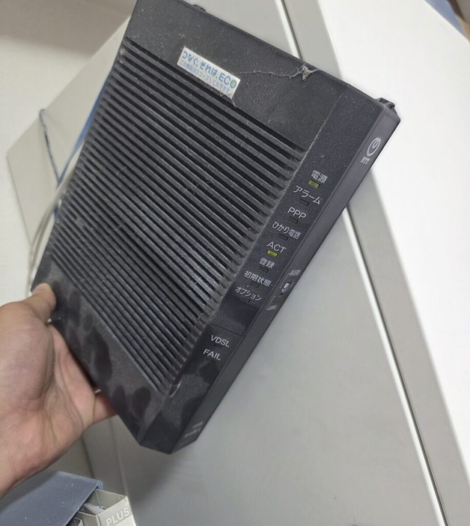 この瞬間、ネットワーク全体のトラブル原因が綺麗に1点へと絞り込まれました。 「インターネット」と「固定電話」という独立した2つのサービスが同時に全滅しているということは、パソコンや市販のルーター単体の故障ではなく、それらの根元にある【NTTのONUやひかり電話ルーターといった黒い機器（HGW）自体の物理的な故障】、もしくは【外からオフィスまで引き込まれているNTTの回線自体が断線・やられている可能性】が極めて高い状態です。
