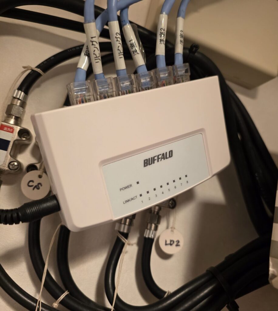 なんと、ネットワークのハブ（HUB）の電源が入っていないではありませんか！ ハブの本体を確認すると、電源ケーブルは壁のコンセントにちゃんと刺さっている状態なのに、通電していることを示す緑色や青色のLEDランプがすべて完全に消灯したまま沈黙していました。コンセントの電気はきているため、これはハブの本体基板が寿命やショート等により故障してしまっている状態です。