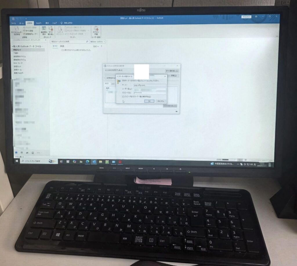 Outlookのメールパスワード入力画面が表示されたデスクトップパソコン