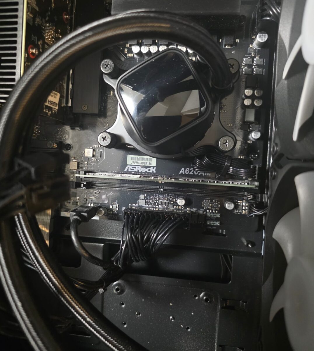 ASRockのマザーボードとCPUクーラー、メモリが確認できるPC内部のクローズアップ
