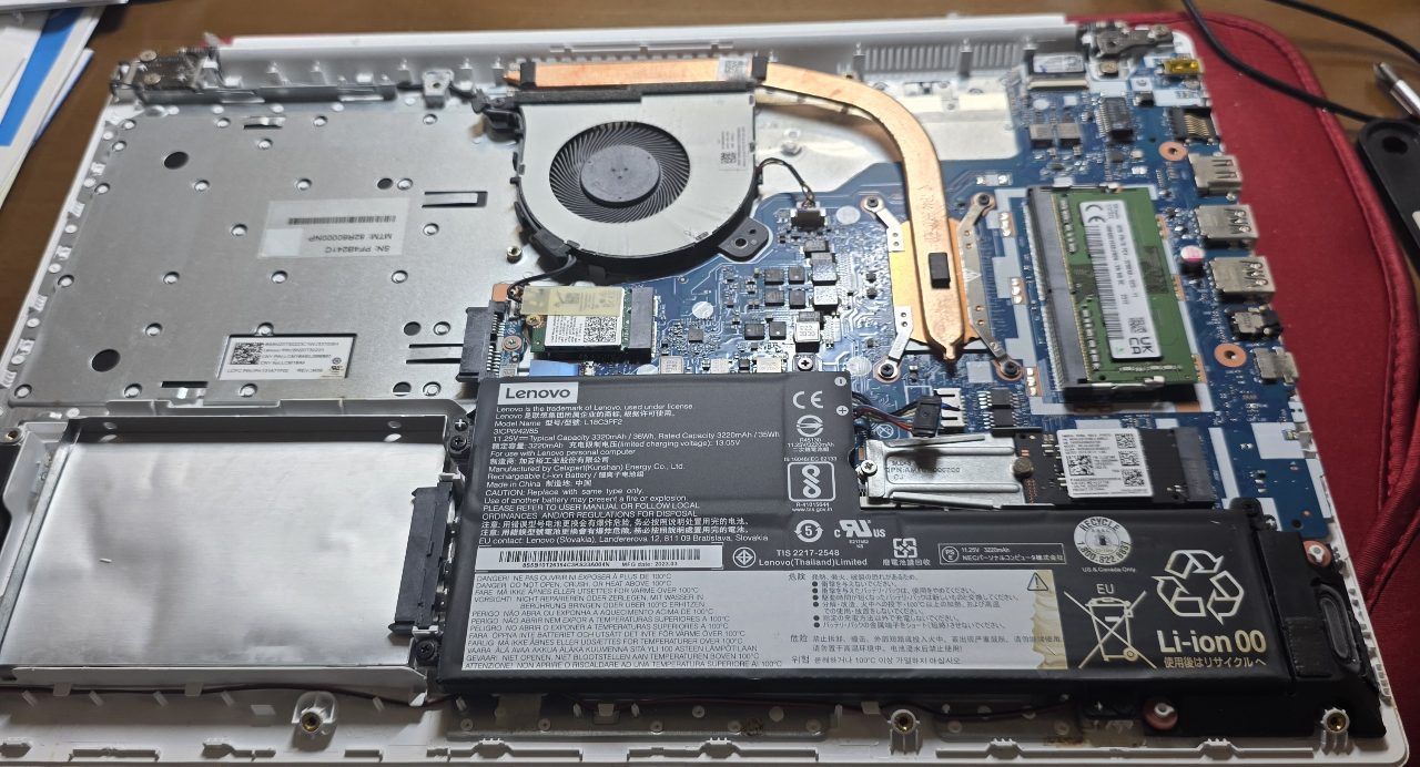 ノートパソコンの底面カバーを外し、内部のWi-Fiモジュールとバッテリーが見える状態