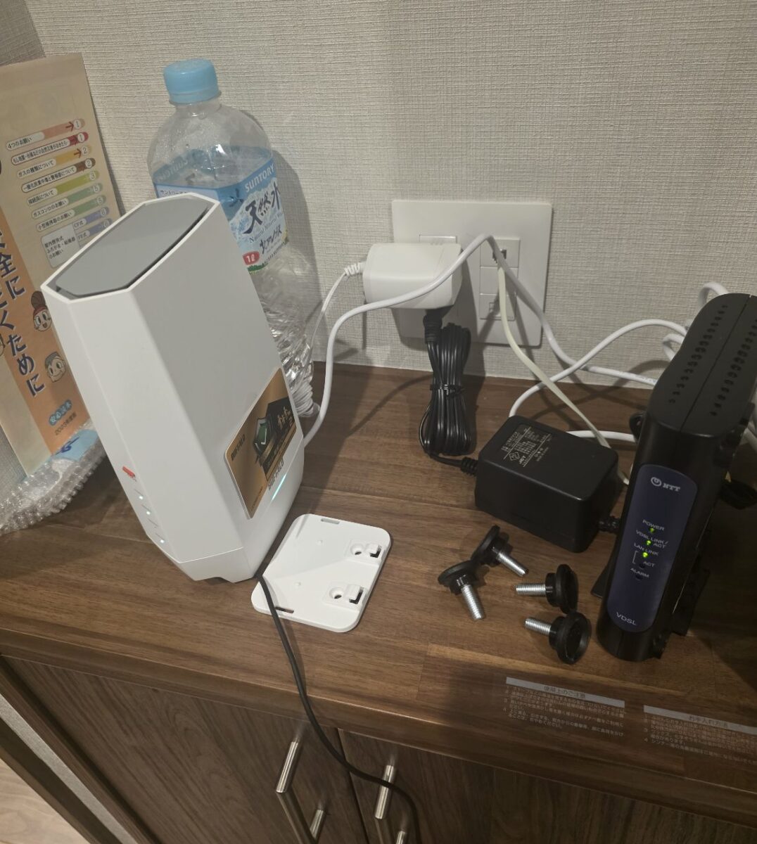 無線ルーターとNTT製VDSL装置が並んで設置され、配線が接続されている様子