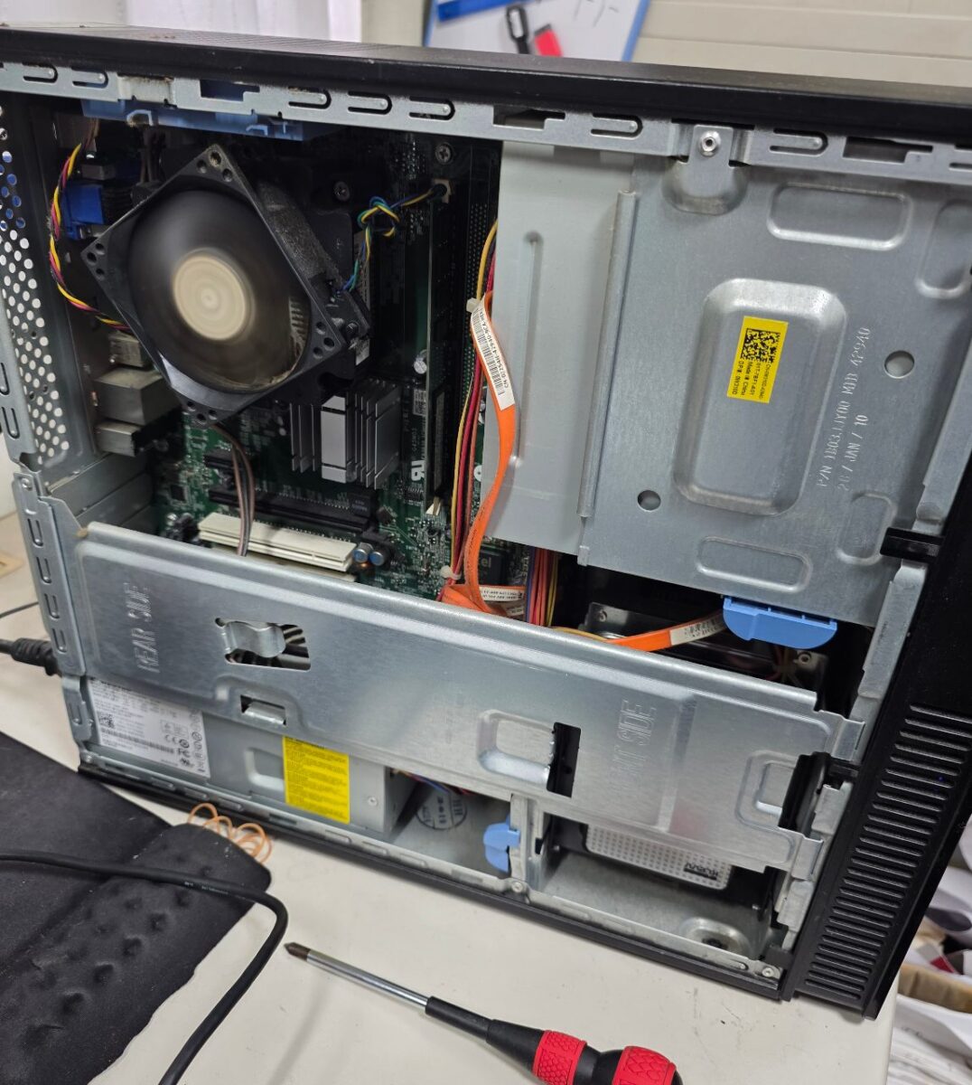 デスクトップPCの側面カバーが外され、内部の基盤やファン、ケーブルが見える状態。