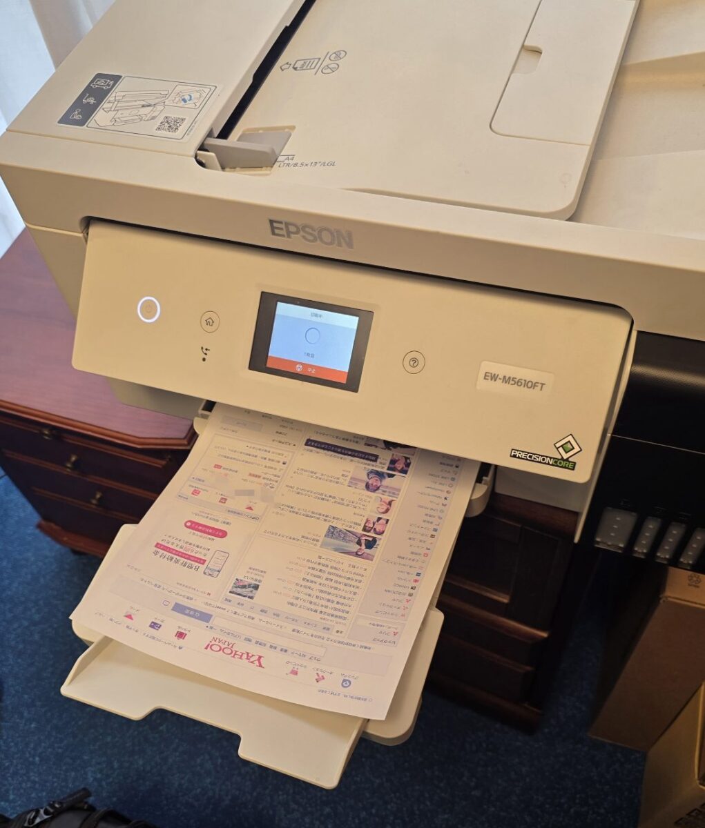 EPSON EW-M5610FTプリンターが印刷中で、排紙トレイにYahoo! JAPANのウェブページが排出されている様子