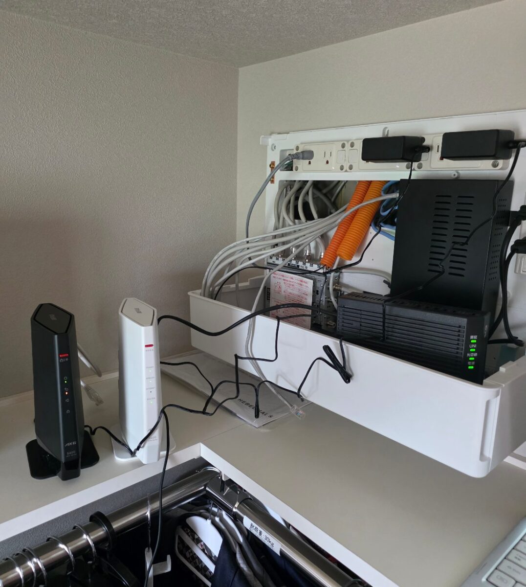 壁面のネットワーク機器収納ボックス内に配線されたケーブルと2台のルーター