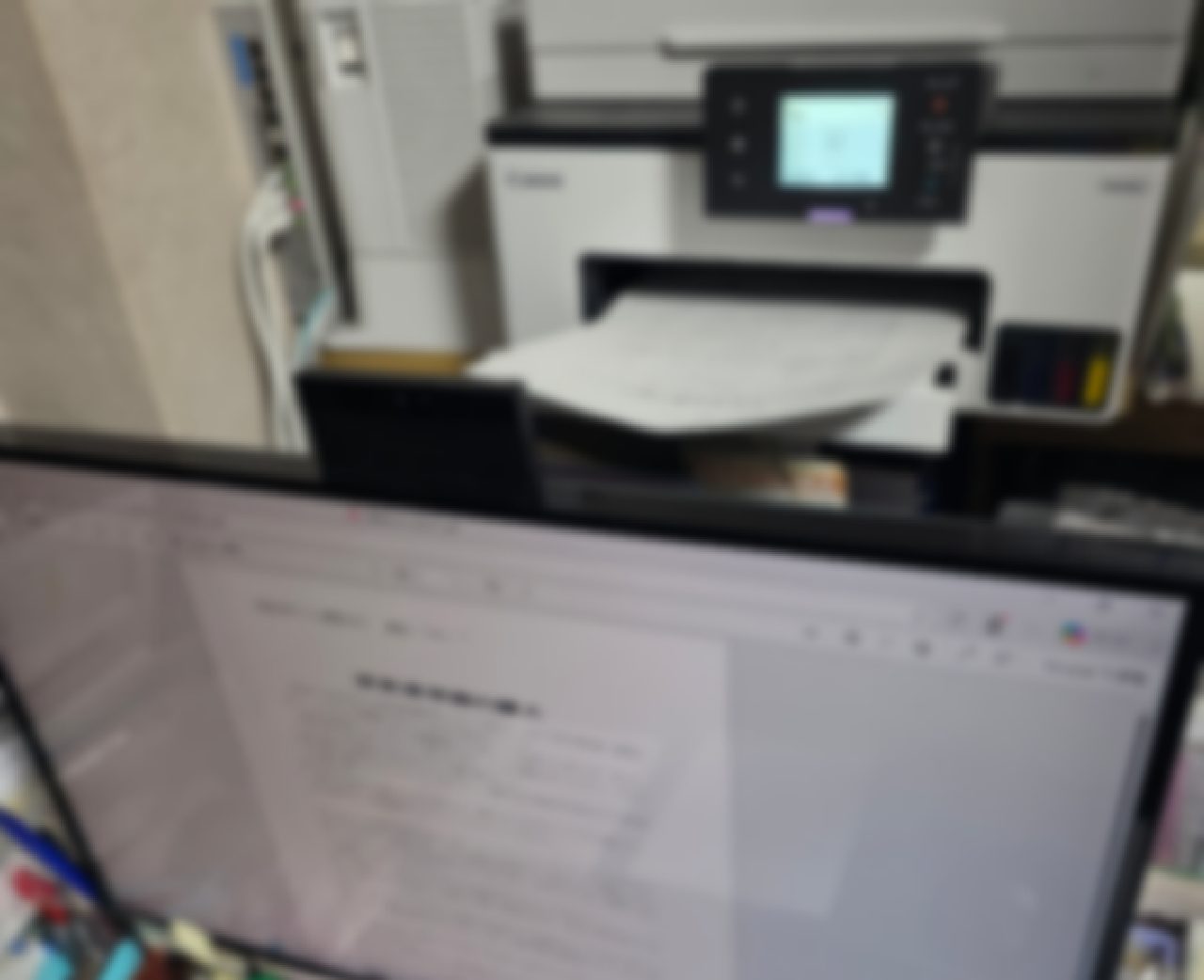 PDFの印刷確認をしているPCとプリンター